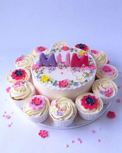 Colourful mothers day cake with cupcakes around